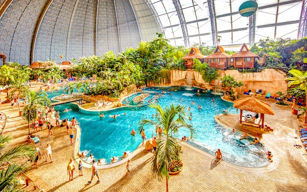Indoor water park with pools and tropical plants at Tropical Islands Resort.