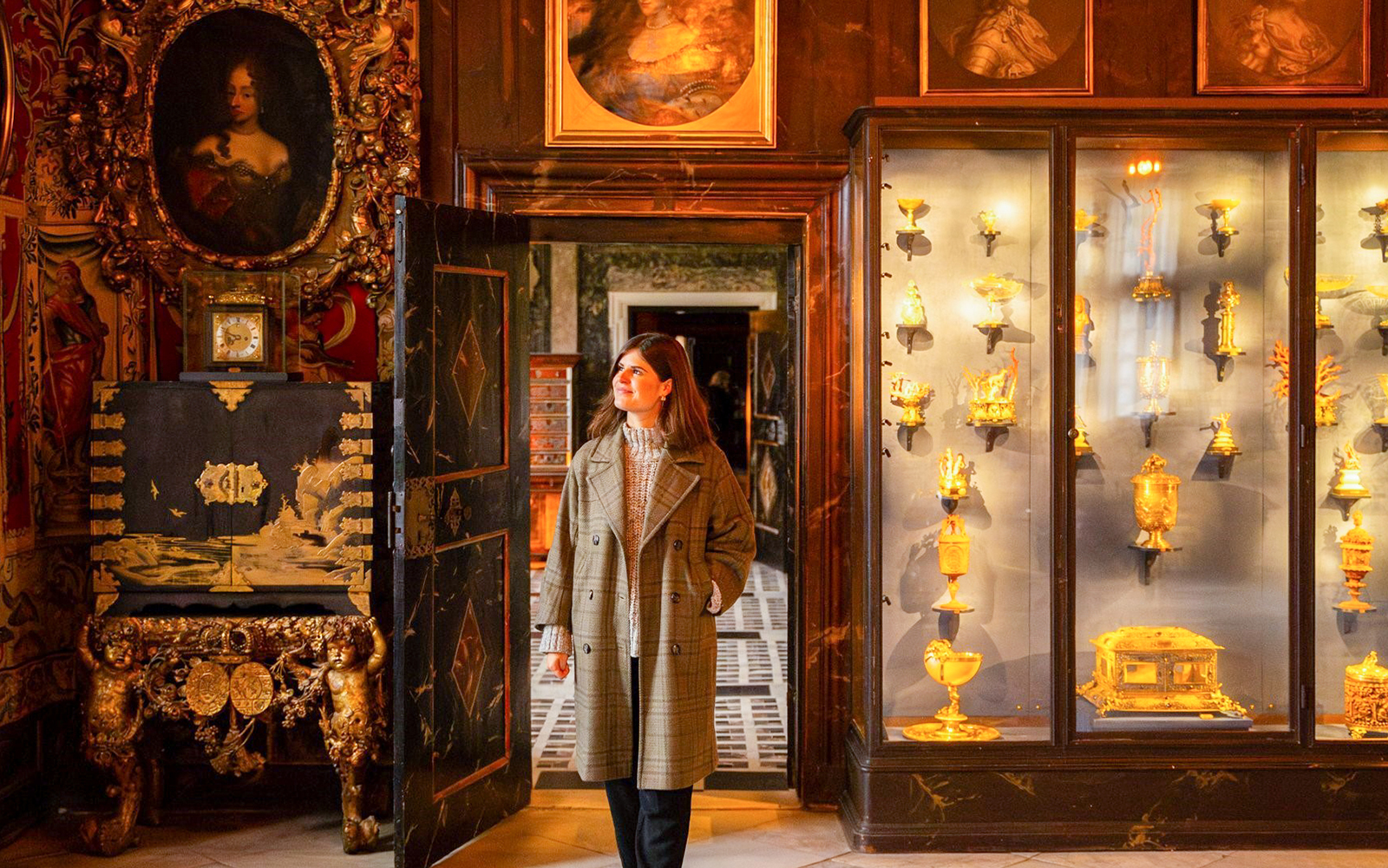 Visitor exploring a historic room with ornate decor and gold artifacts in Copenhagen.