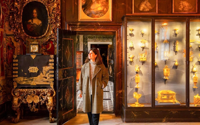 Visitor exploring a historic room with ornate decor and gold artifacts in Copenhagen.