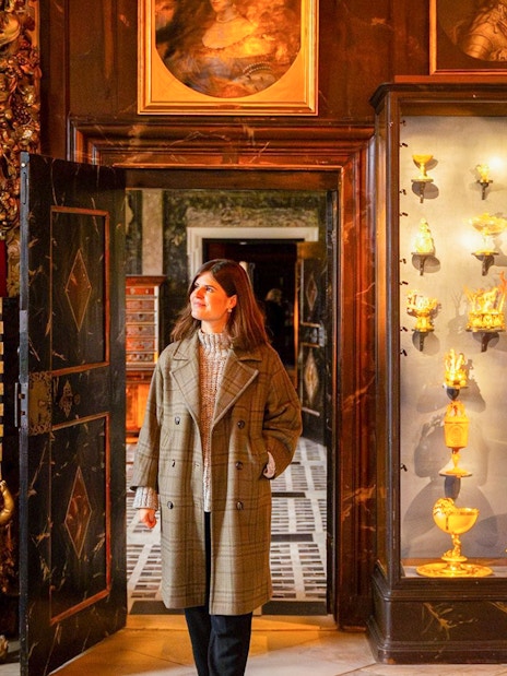 Visitor exploring a historic room with ornate decor and gold artifacts in Copenhagen.