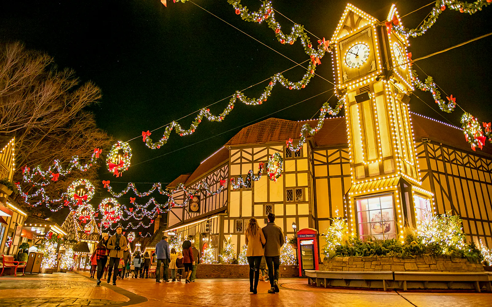 Busch Gardens Williamsburg festive lights and clock tower at night.