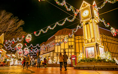 Busch Gardens Williamsburg festive lights and clock tower at night.