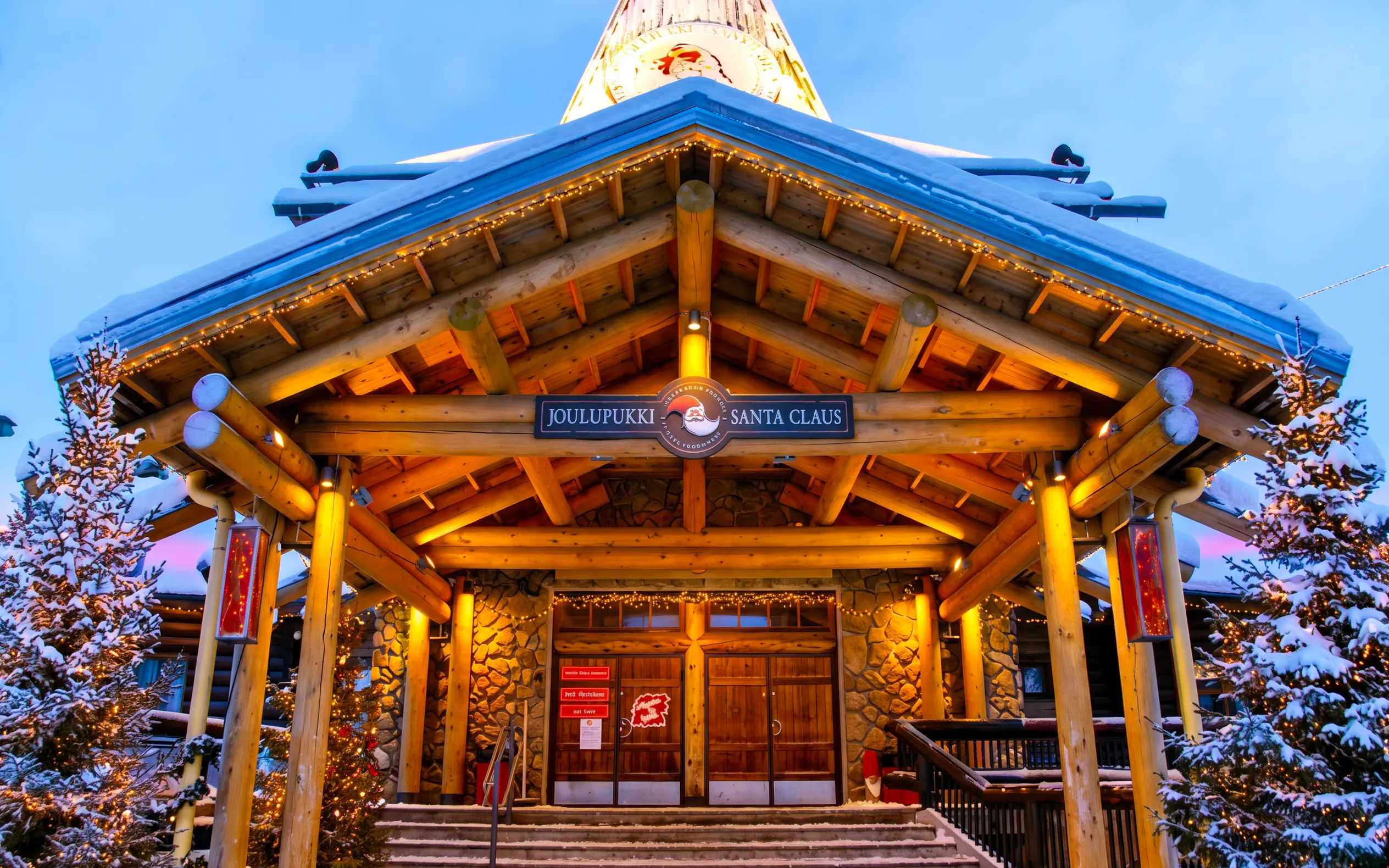 Santa Claus Village entrance with snow-covered roof and festive lights, Rovaniemi.