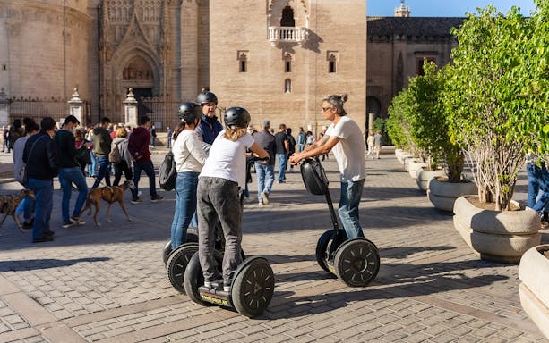 Tourists on Segways near Seville Cathedral during a guided tour.