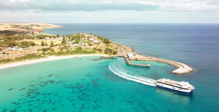 Sealink ferry approaching Penneshaw dock on Kangaroo Island, surrounded by turquoise waters.