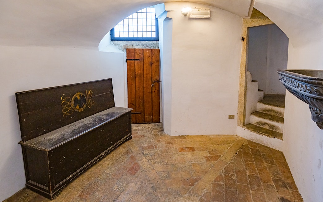 Stone staircase and wooden bench inside Palazzo Ducale di Urbino, Italy.