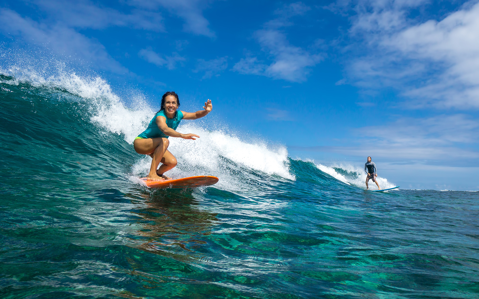 Surfer riding a wave at a beach in Bali, Indonesia.