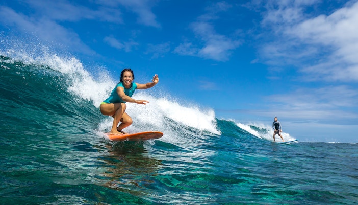 Surfer riding a wave at a beach in Bali, Indonesia.