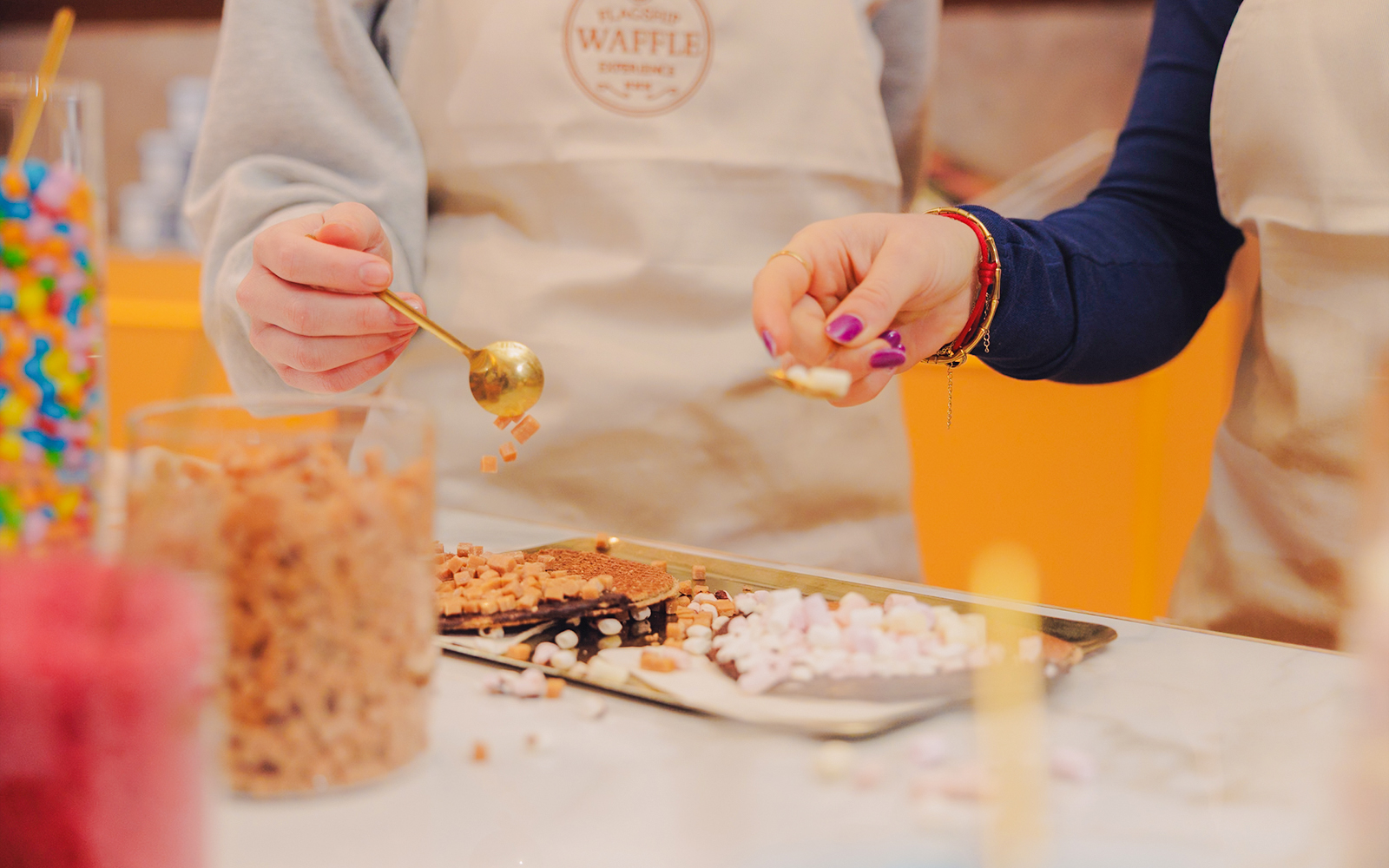 Guests decorating stroopwafels with toppings at a workshop in Amsterdam.