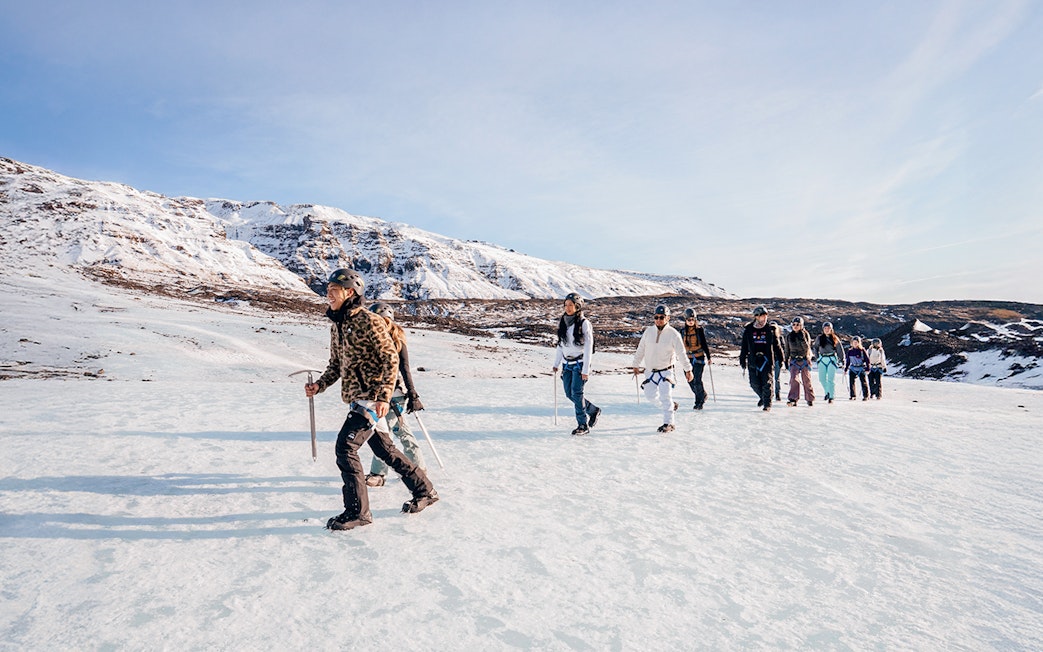 Guests trekking on Vatnajökull Glacier with ice axes in Iceland.