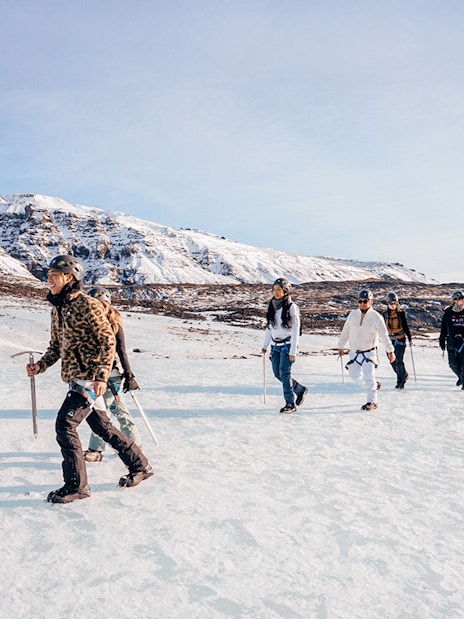 Guests trekking on Vatnajökull Glacier with ice axes in Iceland.