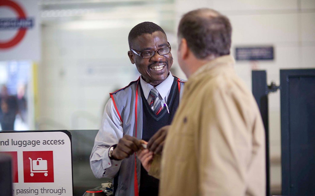 Customer interacting with staff while boarding Stansted Express.