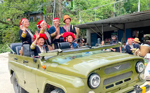 Sapa locals in traditional attire on a jeep during a full day tour from Hanoi.