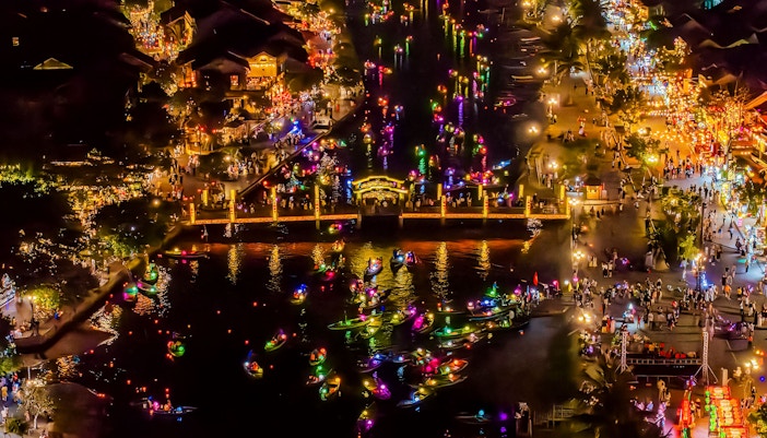 Hoi An river at night with colorful lanterns and boats, bustling with people.