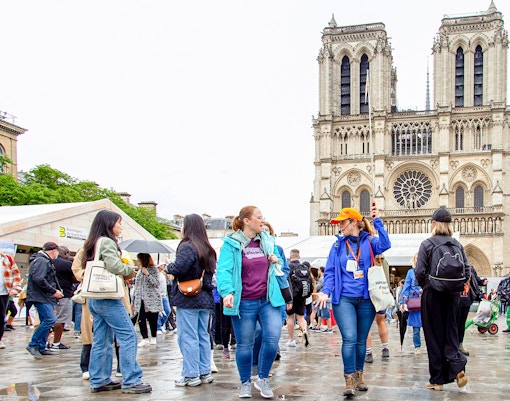 Notre Dame Cathedral facade with tourists on outdoor walking tour, Paris, includes crypt entry.