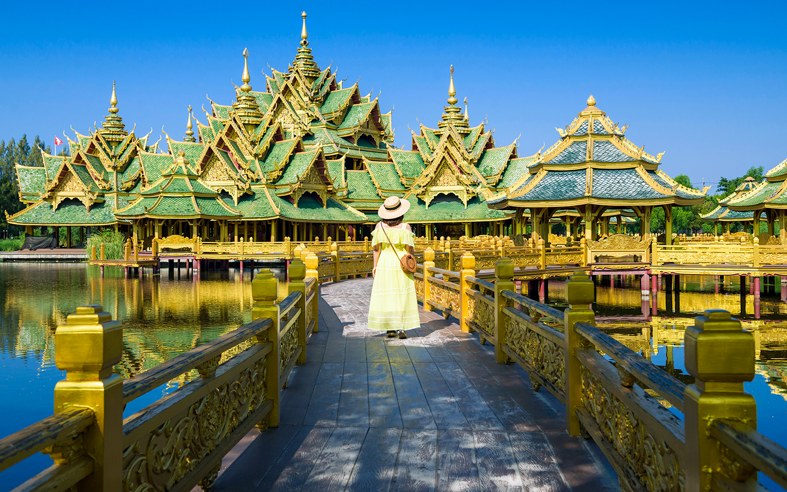 Woman exploring golden pavilion in Ancient City, Muang Boran, Thailand.