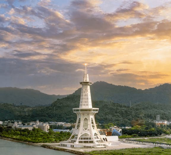 Maha Tower at sunset with surrounding landscape and water.
