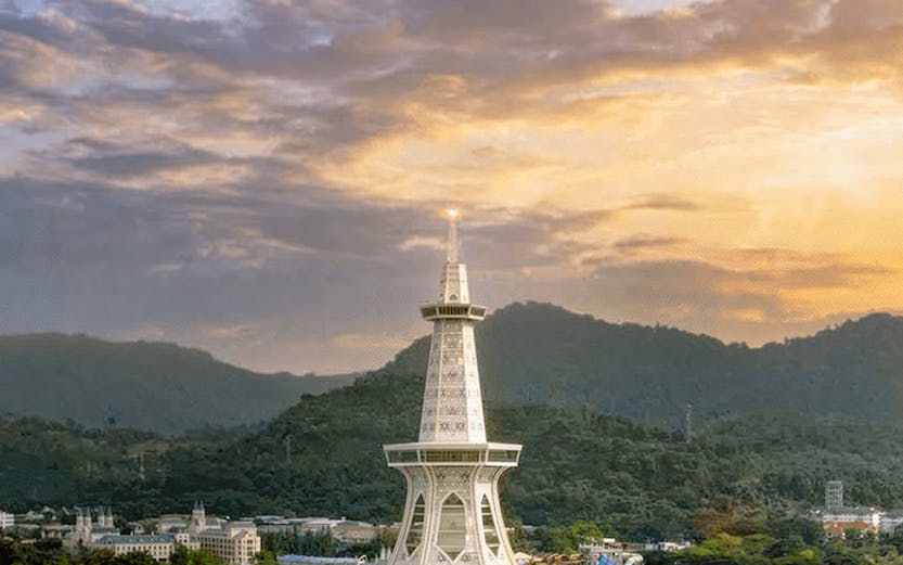 Maha Tower at sunset with surrounding landscape and water.