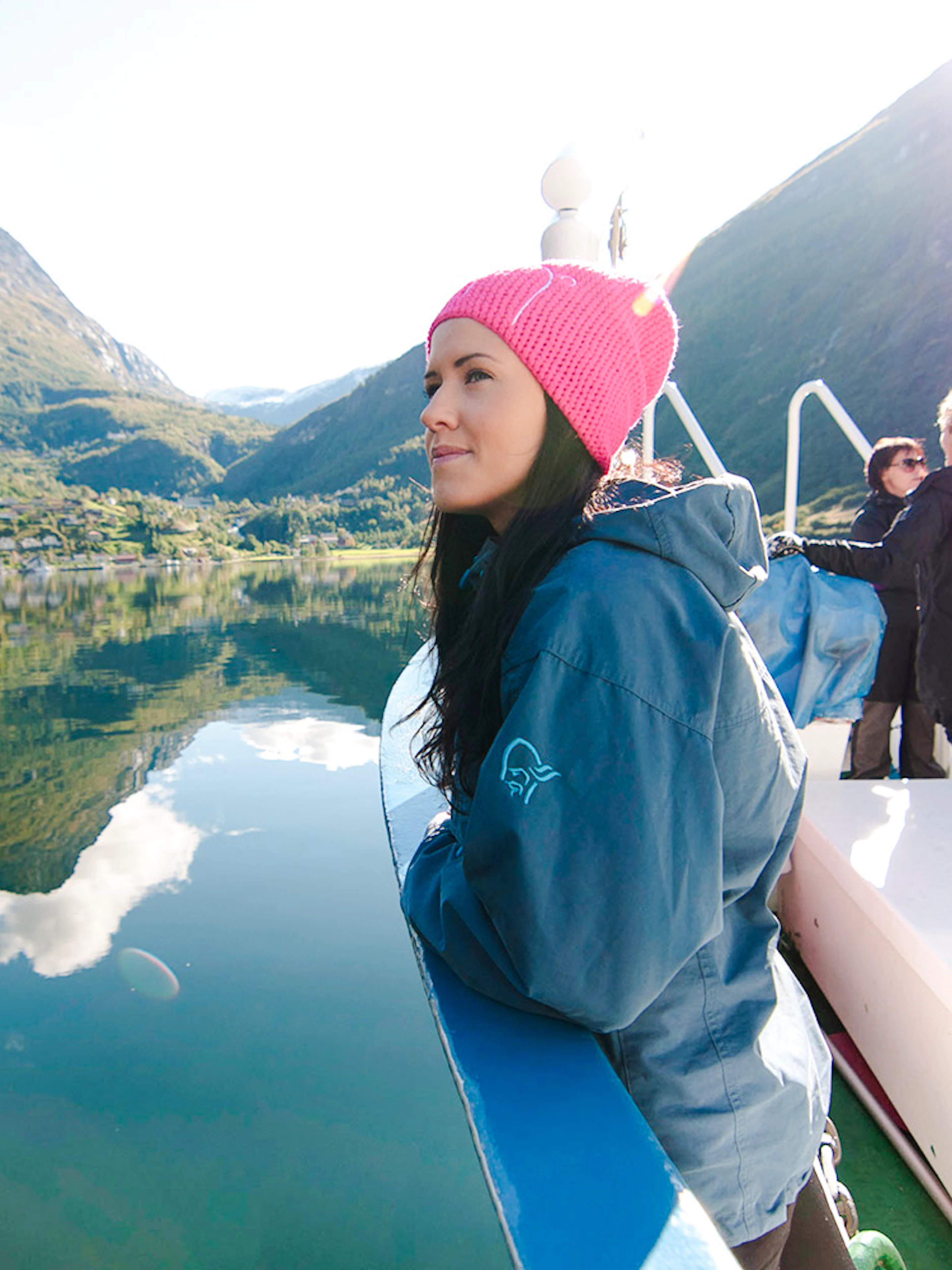 Geiranger fjord cruise with passengers enjoying scenic mountain views.