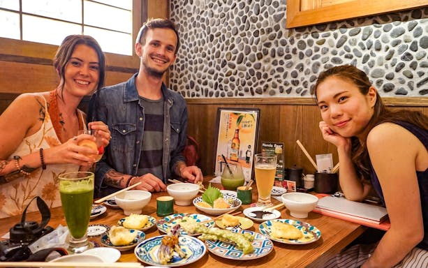 Group enjoying traditional Japanese dishes on Kyoto Night Foodie Tour.