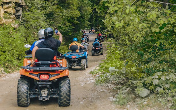 ATV riders on a forest trail during a Phuket adventure tour.