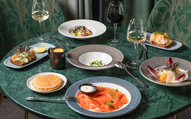 Dishes of smoked salmon, salad, and wine at Flora Danica on the Champs Elysées, Paris.
