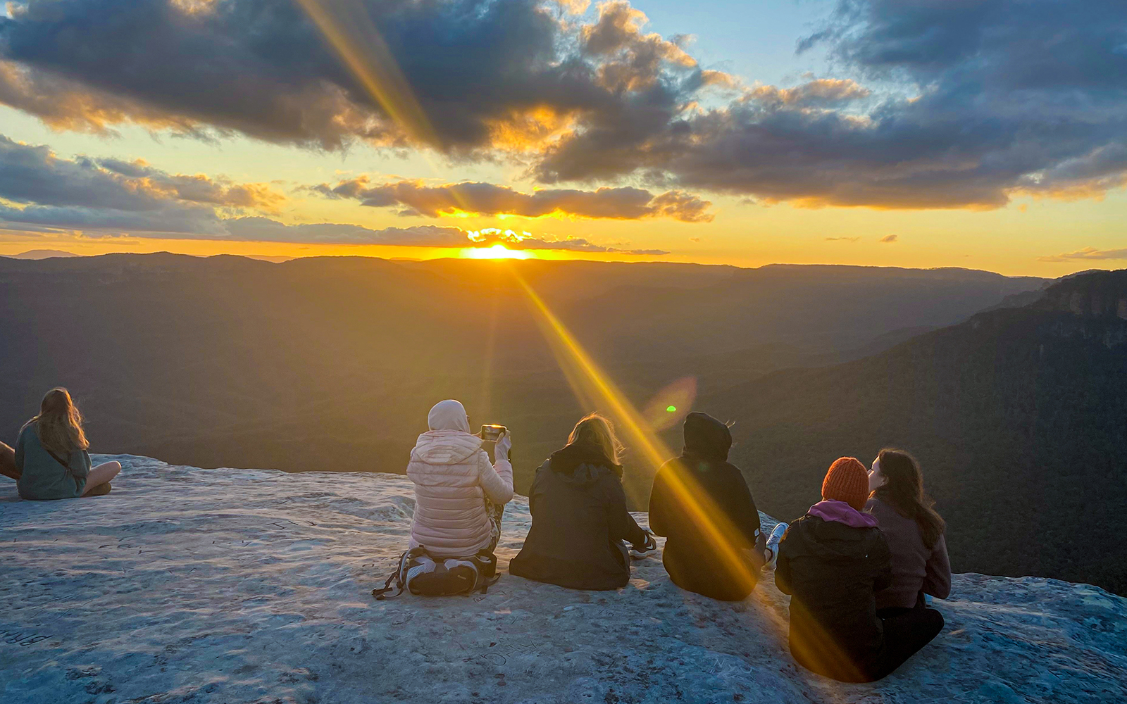 Tourists taking in the views of Jamison Valley at sunset on the Blue Mountains Sunset & Wilderness Day Trip from Sydney