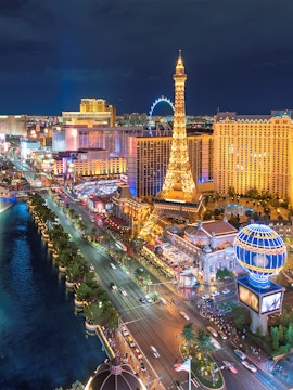 Las Vegas Strip at night with Eiffel Tower replica and illuminated buildings.