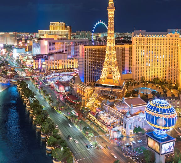 Las Vegas Strip at night with Eiffel Tower replica and illuminated buildings.