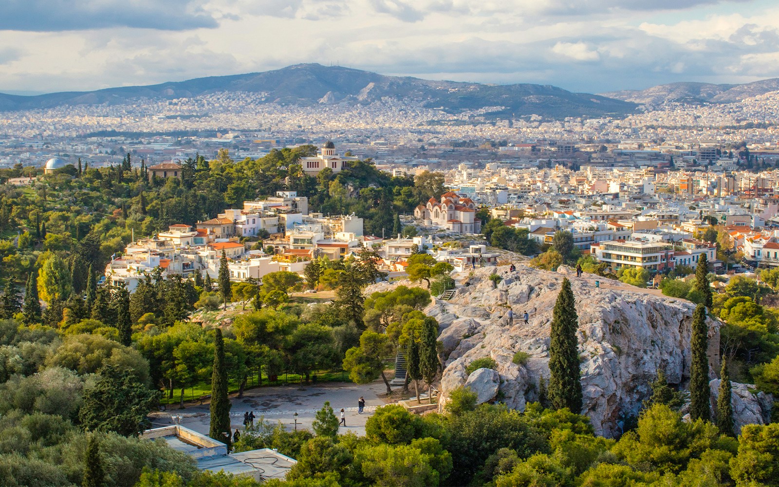 Areopagus Hill overlooking Athens cityscape with distant mountains.