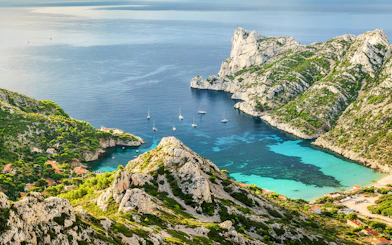 Sailboats in a turquoise cove at Calanques National Park, Marseille, Mediterranean Sea.