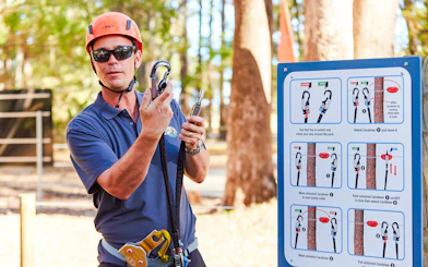 Guide explaining carabiner use at Ludlow Tuart Forest, Western Australia.