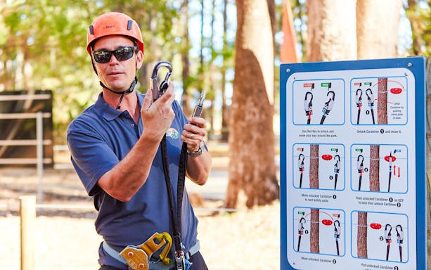 Guide explaining carabiner use at Ludlow Tuart Forest, Western Australia.