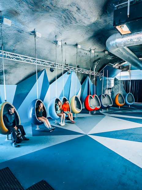 People seated in hanging chairs in the Cinema Room at Matterhorn Glacier Paradise.