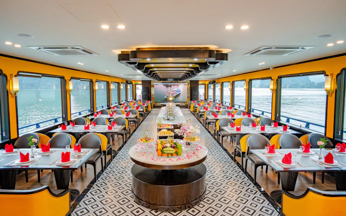 Dining area on Phong Hai Harmony Cruise with set tables and river views.