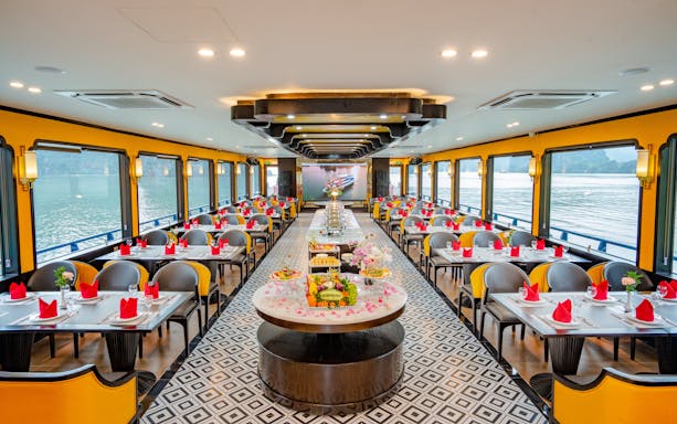 Dining area on Phong Hai Harmony Cruise with set tables and river views.
