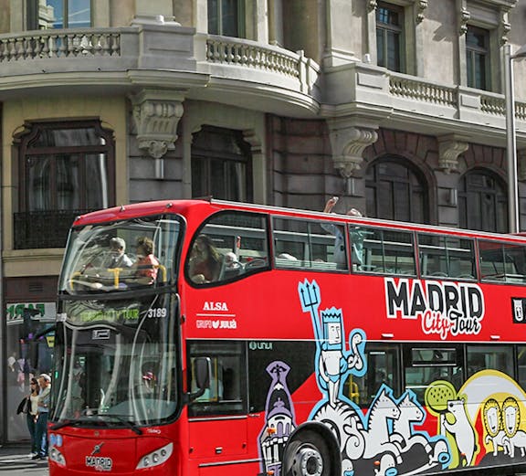 Red double-decker bus for Madrid City Tour on a city street.