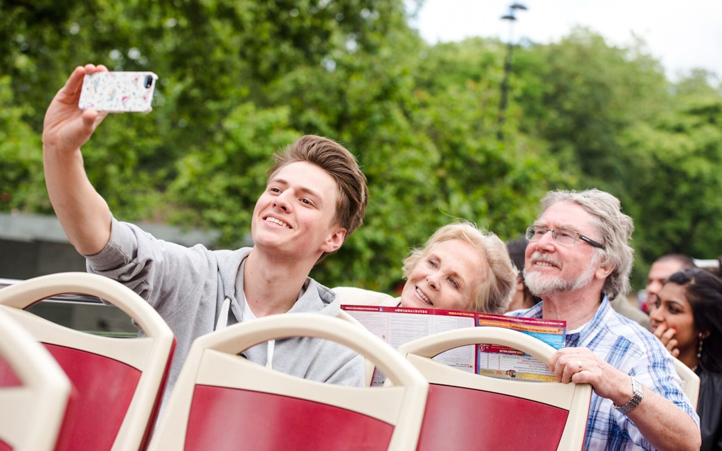 Family taking a selfie on a Big Bus hop on hop off tour.