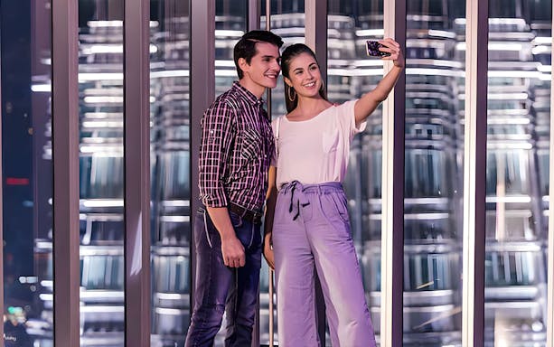 Couple taking a selfie at the Petronas Twin Towers observation deck in Kuala Lumpur.