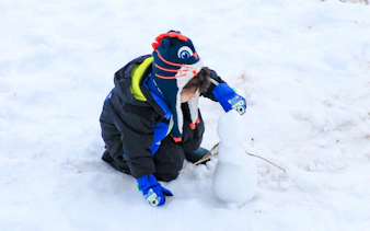 Child building a snowman during Valle Nevado tour in Santiago.