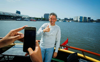 Man giving thumbs up on a boat during Dutch Pancake cruise in Amsterdam.