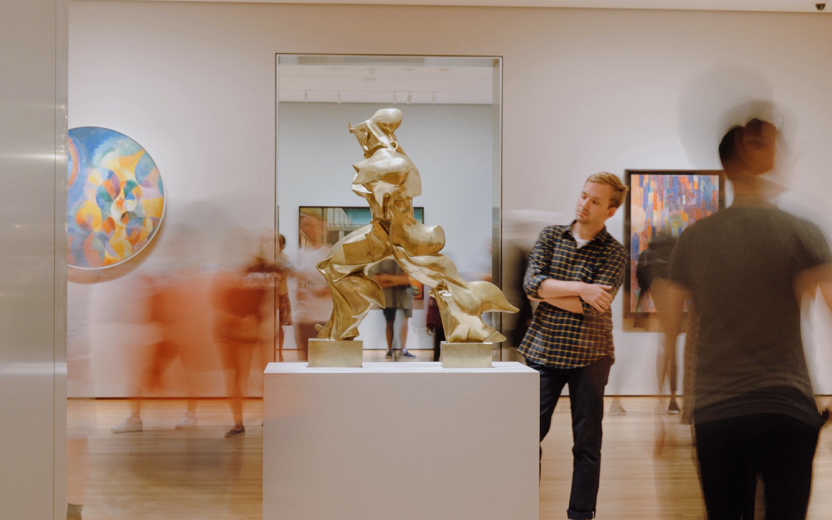 Visitors viewing sculptures and paintings at The Museum of Modern Art, New York.