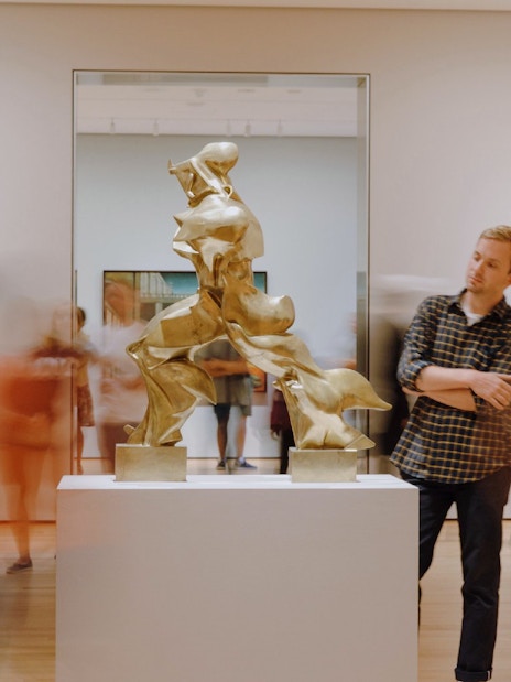 Visitors viewing sculptures and paintings at The Museum of Modern Art, New York.