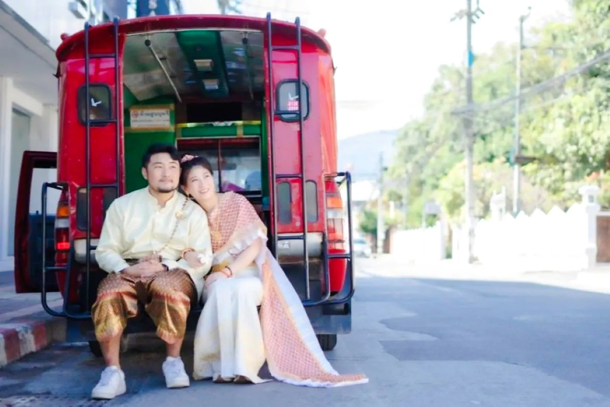 Couple in traditional Thai costumes sitting in a red tuk-tuk at Love Season Studio, Chiang Mai.