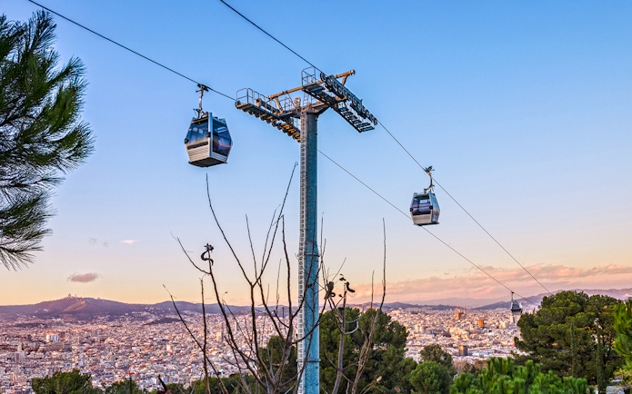 Montjuic cable car over Barcelona cityscape at evening, Spain.