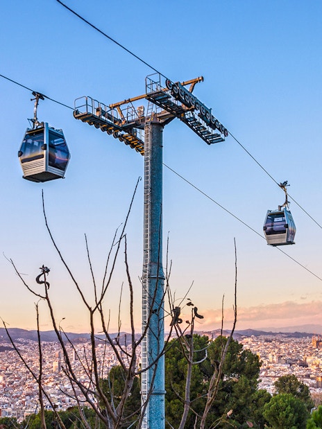 Montjuic cable car over Barcelona cityscape at evening, Spain.
