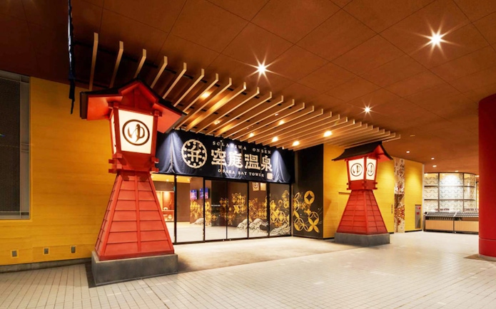 Entrance to Solaniwa Onsen with traditional red lanterns in Osaka, Japan.