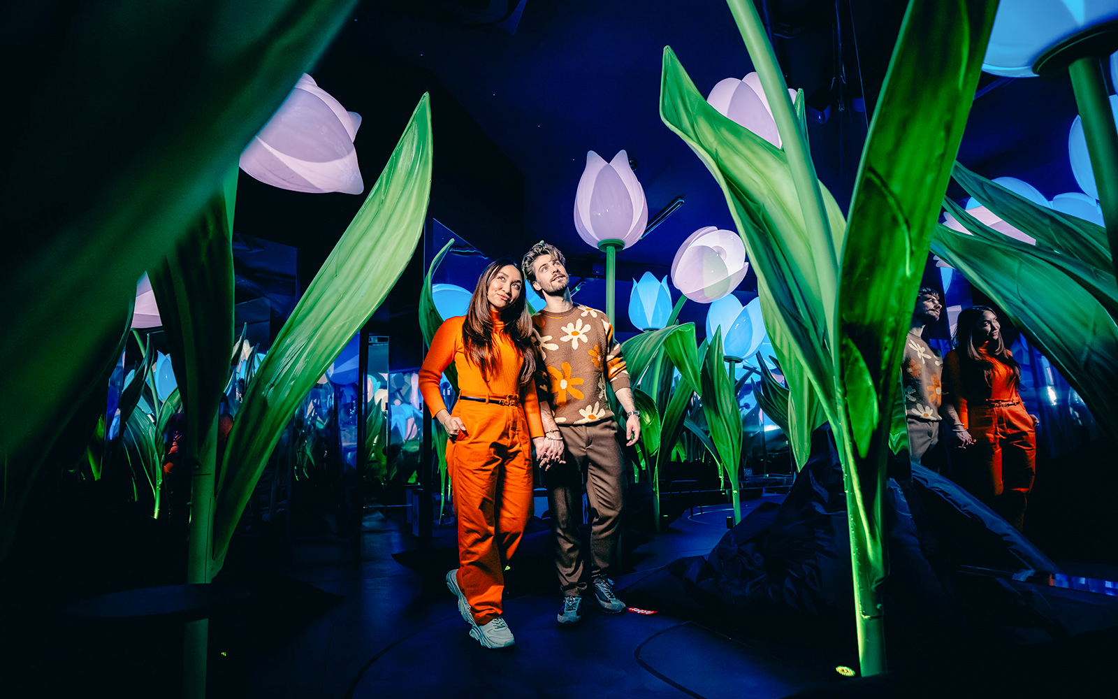 Guests walking through illuminated tulip exhibit in Highlights of Holland experience.