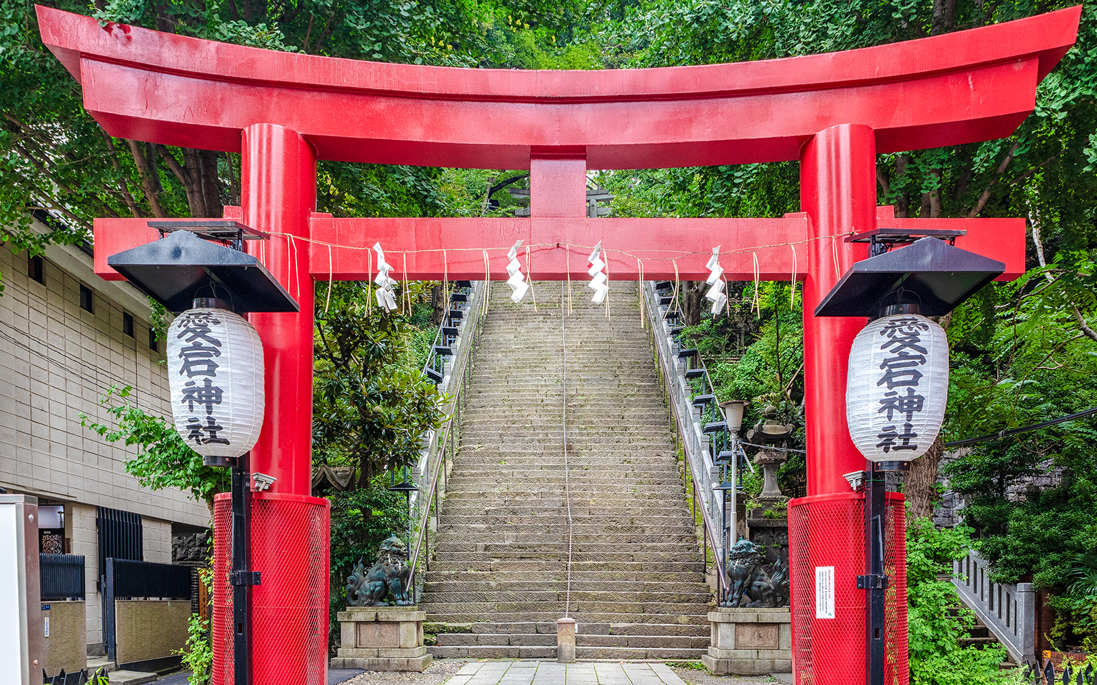 Steep stone stairs leading to Atago Jinja Shrine in Tokyo under a red torii gate.