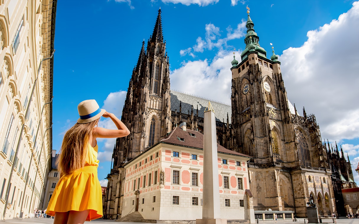 Woman admiring St. Vitus Cathedral in Prague Castle complex, Czech Republic.
